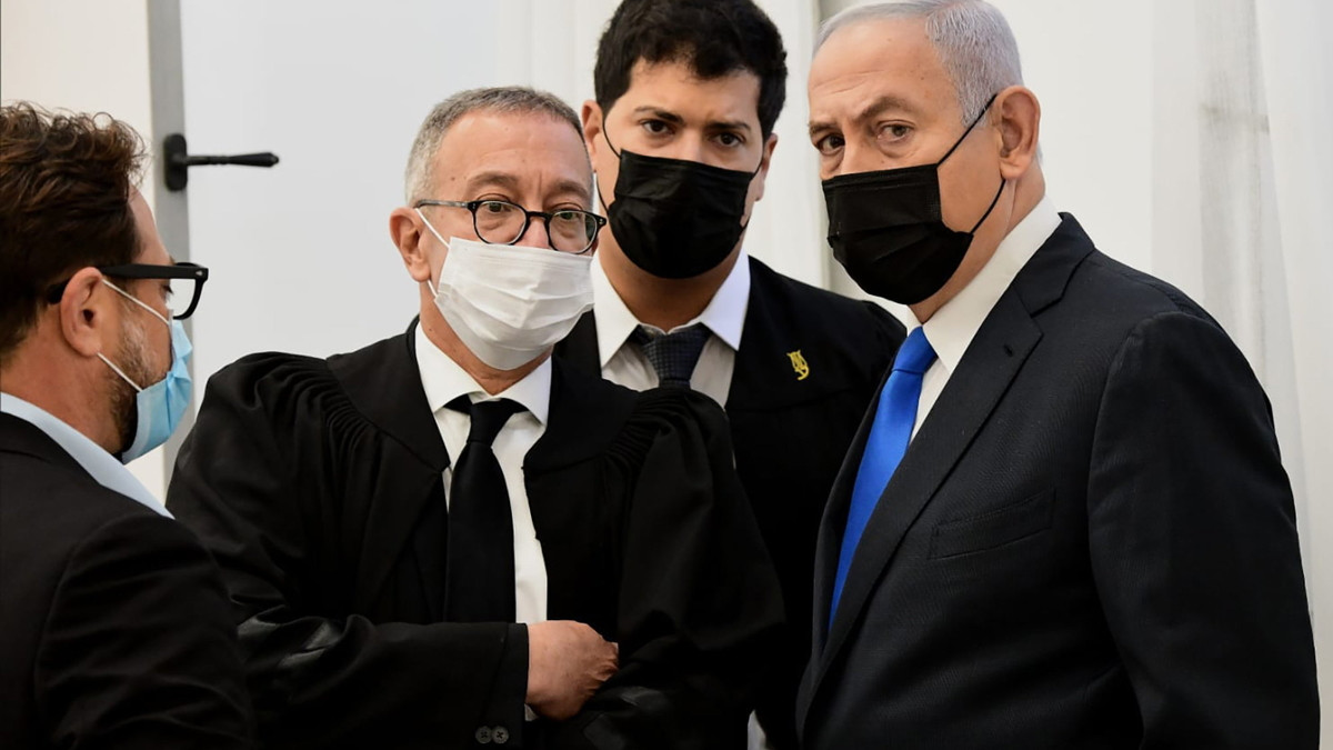 Benjámin Netanjahu izraeli miniszterelnök (j) ügyvédeivel beszél perének tárgyalása előtt a jeruzsálemi körzeti bíróságon  2021. február 8-án, néhány héttel a március 23-i parlamenti választások előtt. Az izraeli kormányfő ellen ellen 2020-ban nyújtott be a főügyész vádiratot csalás, közhivatallal visszaélés és korrupció vádjával.