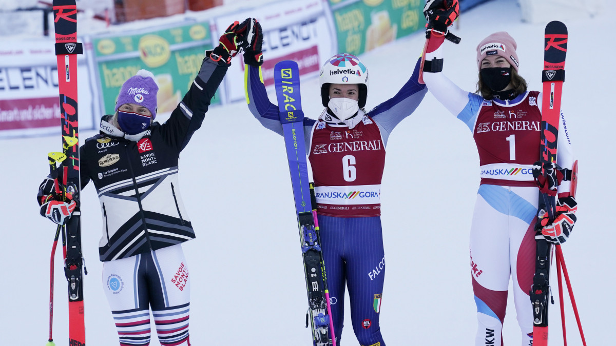 A második helyezett francia Tessa Worley (b), a győztes olasz Marta Bassino (k), és a harmadik helyezett svájci Michelle Gisin a női alpesi sí világkupa óriás-műlesiklás számának eredményhidetésén a szlovéniai Kranjska Gorában 2021. január 16-án.