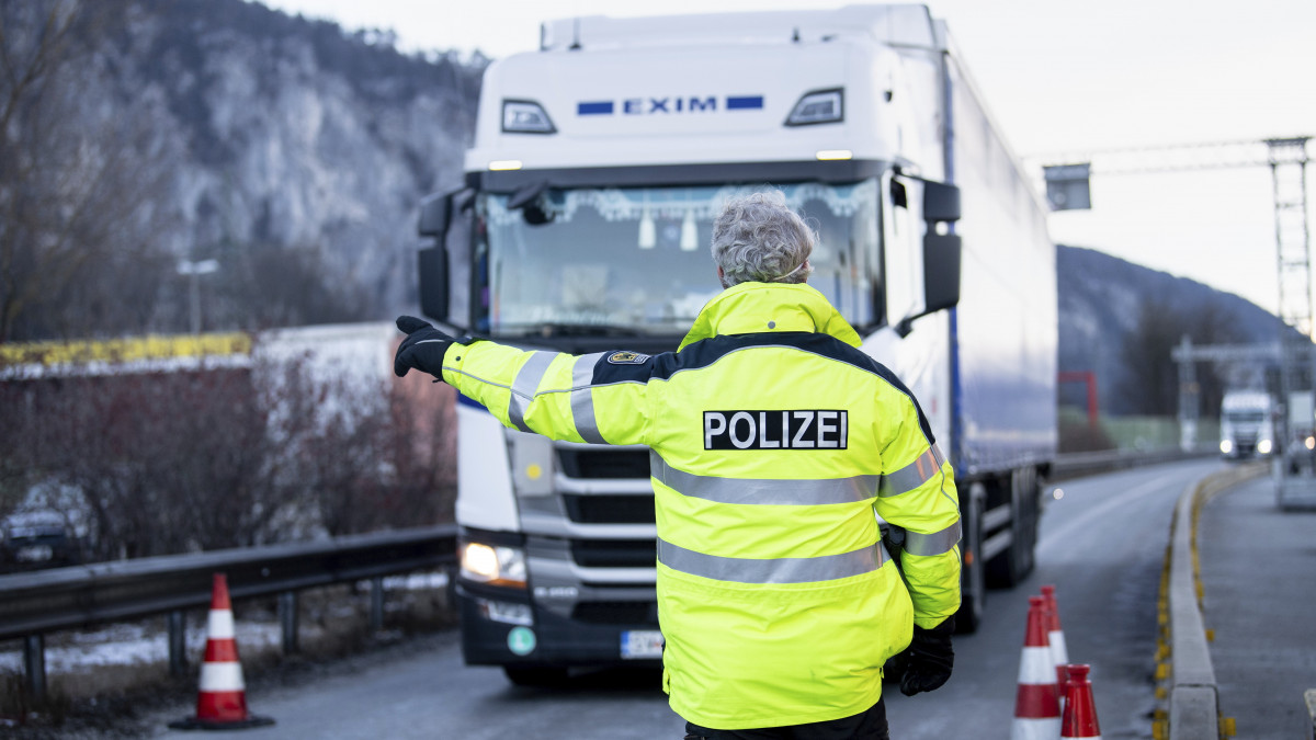 Ausztriából érkező teherautót irányít ellenőrző ponthoz egy rendőr az A 93-as autópályán, a német határon, Kiefersfelden térségében 2021. február 15-én. Az előző nap lépet hatályba az a német rendelkezés, amely a koronavírus-járvány miatt szigorítja a belépést az osztrák Tirol tartományból.