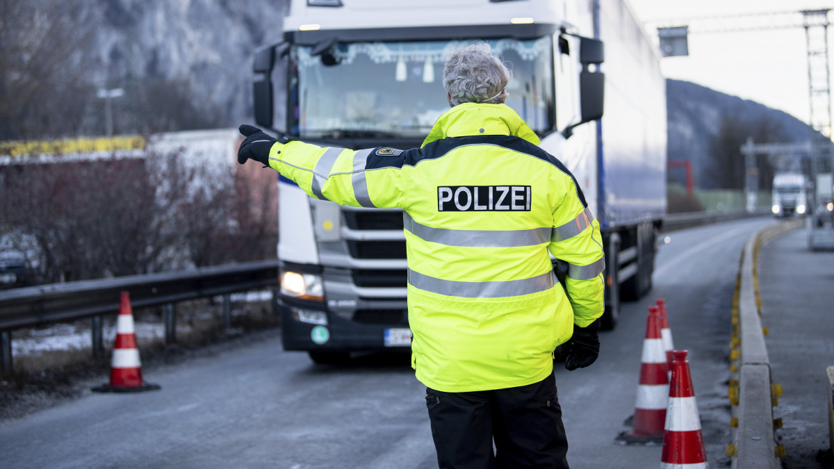 Ausztriából érkező teherautót irányít ellenőrző ponthoz egy rendőr az A 93-as autópályán, a német határon, Kiefersfelden térségében 2021. február 15-én. Az előző nap lépet hatályba az a német rendelkezés, amely a koronavírus-járvány miatt szigorítja a belépést az osztrák Tirol tartományból.
