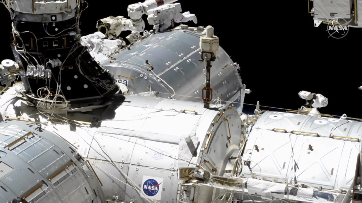 A NASA videofelvételéről készített képen Mike Hopkins (középen, j) és Victor Glover (középen, b) amerikai űrhajósok nagy sebességű adatkapcsolati berendezést szerelnek fel a Föld körül keringő Nemzetközi Űrállomás Európai laboratóriumának külső falán a 2021. január 27-i űrsétájukon.