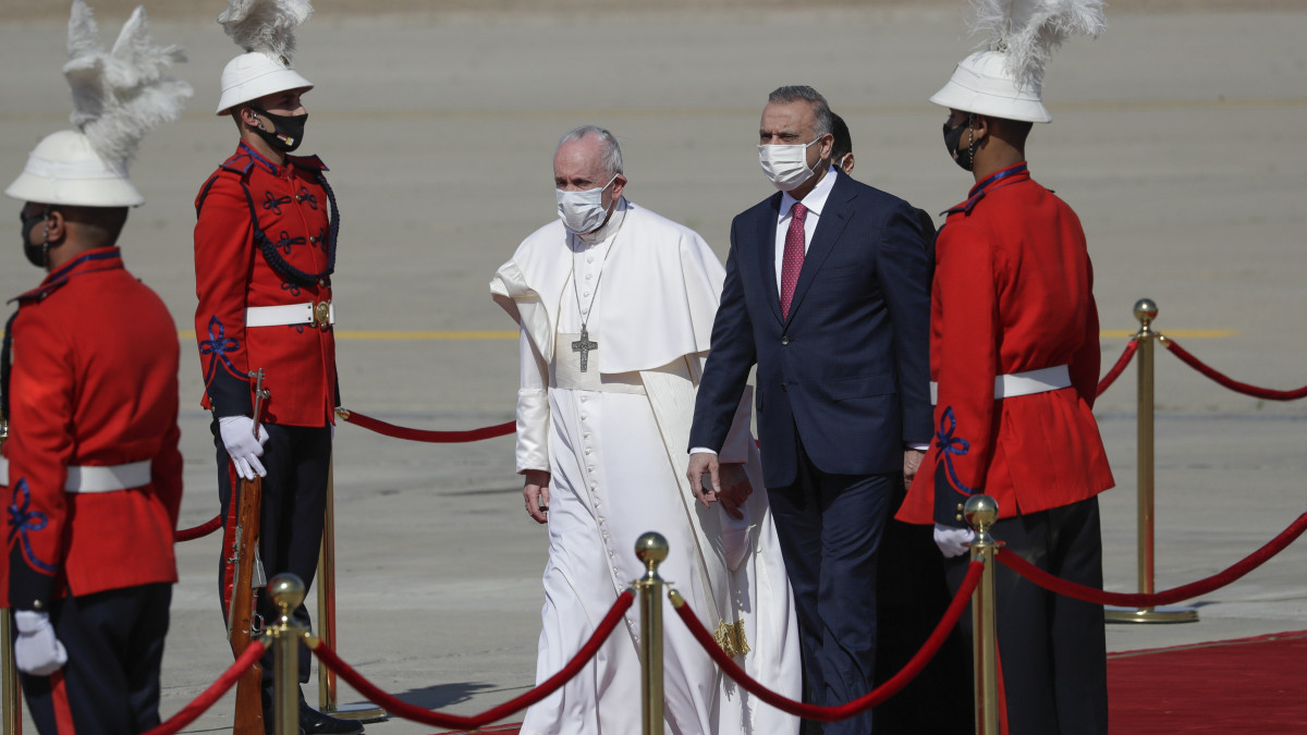 Musztafa al-Kádimi iraki miniszterelnök (j) üdvözli Ferenc pápát a bagdadi repülőtéren 2021. március 5-én. Ferenc pápa négynapos történelmi jelentőségű látogatásra érkezett a közel-keleti országba, ahol előtte még nem járt katolikus egyházfő.