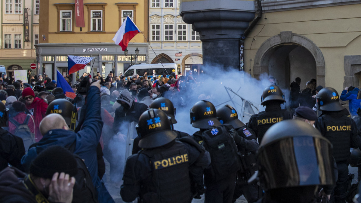 A koronavírus-járvány miatt bevezetett korlátozások ellen tüntetőket feltartóztatják rendőrök a prágai Óváros téren 2021. március 7-én.