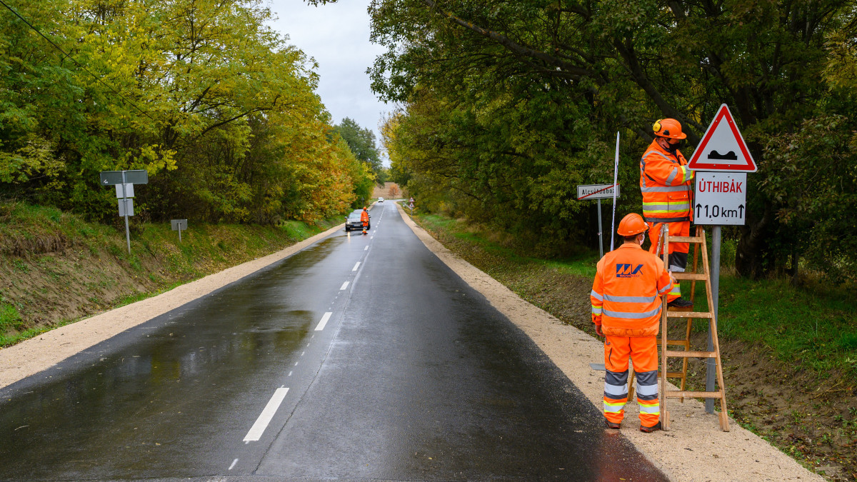 A Magyar Közút Nonprofit Kft. munkatársai leszerelik a korábbi úthibákra figyelmeztető táblát a felújított Biatorbágy-Etyek-Alcsútdoboz összekötő út alcsútdobozi szakaszán 2020. október 30-án.