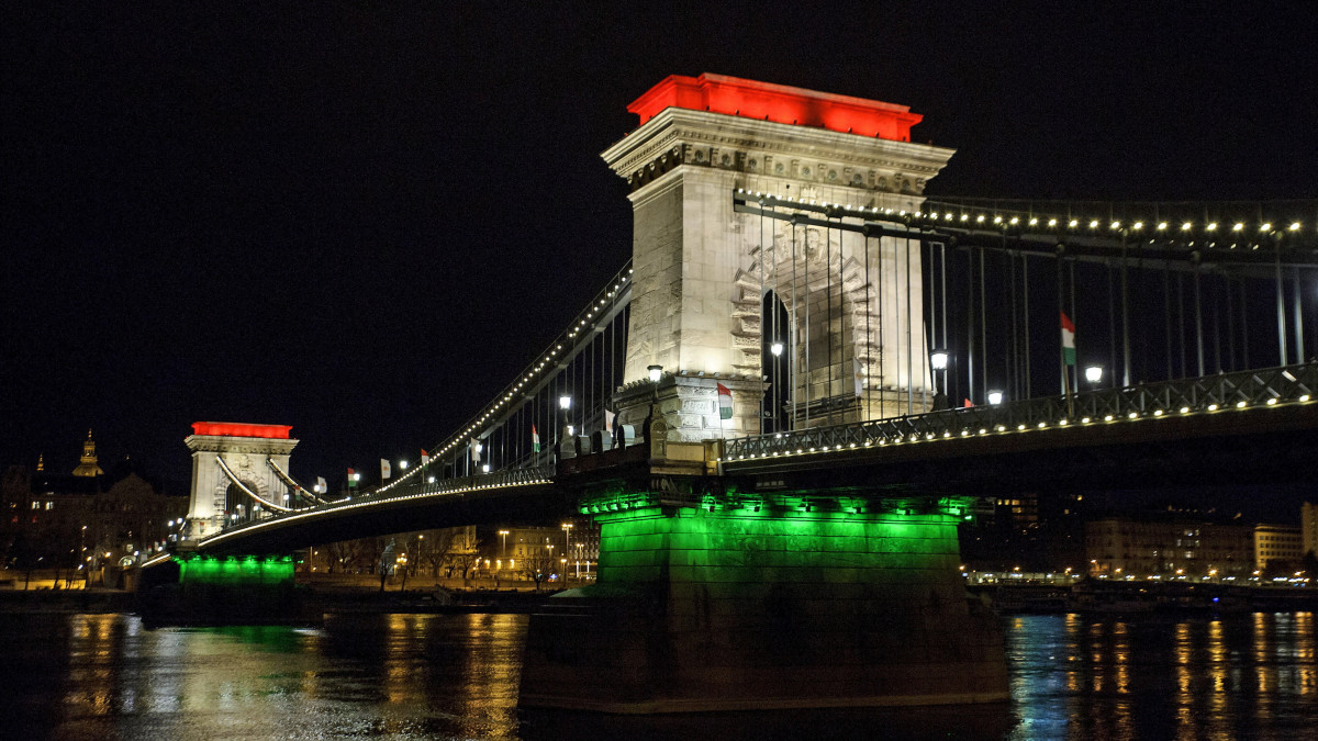 Díszkivilágítás a nemzeti ünnep alkalmából a Lánchídon és a Hotel Clark Budapest épületén 2021. március 14-én.