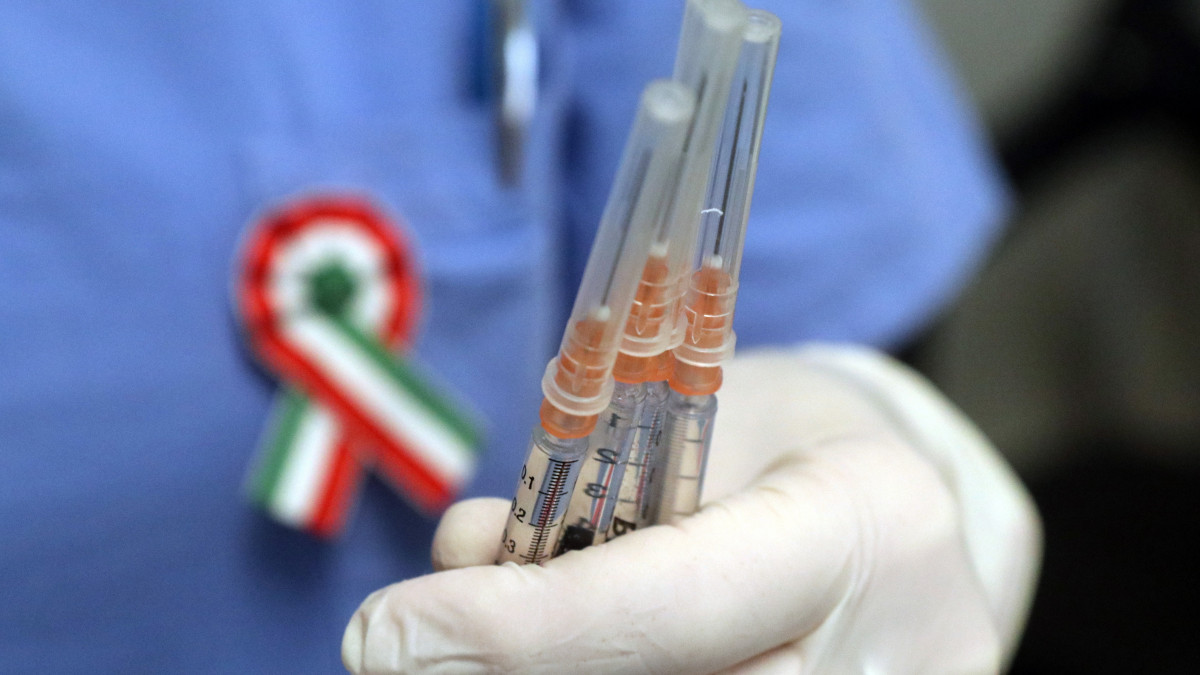Az orosz Szputnyik V koronavírus elleni oltóanyagával töltött fecskendők egy kokárdát viselő ápolónő kezében a Borsod-Abaúj-Zemplén Megyei Központi Kórház és Egyetemi Oktatókórházban kialakított oltóponton 2021. március 15-én.