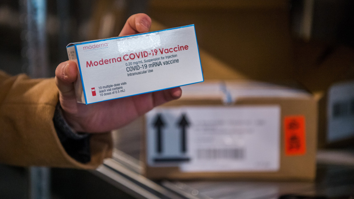 A Moderna amerikai biotechnológiai cég újonnan érkezett, koronavírus elleni oltóanyagát tartalmazó dobozt mutatja a fővárosi kormányhivatal munkatársa az intézmény parkolójában, a vakcinák fogadására kialakított logisztikai bázison, a XIII. kerületi Teve utcában 2021. március 23-án.