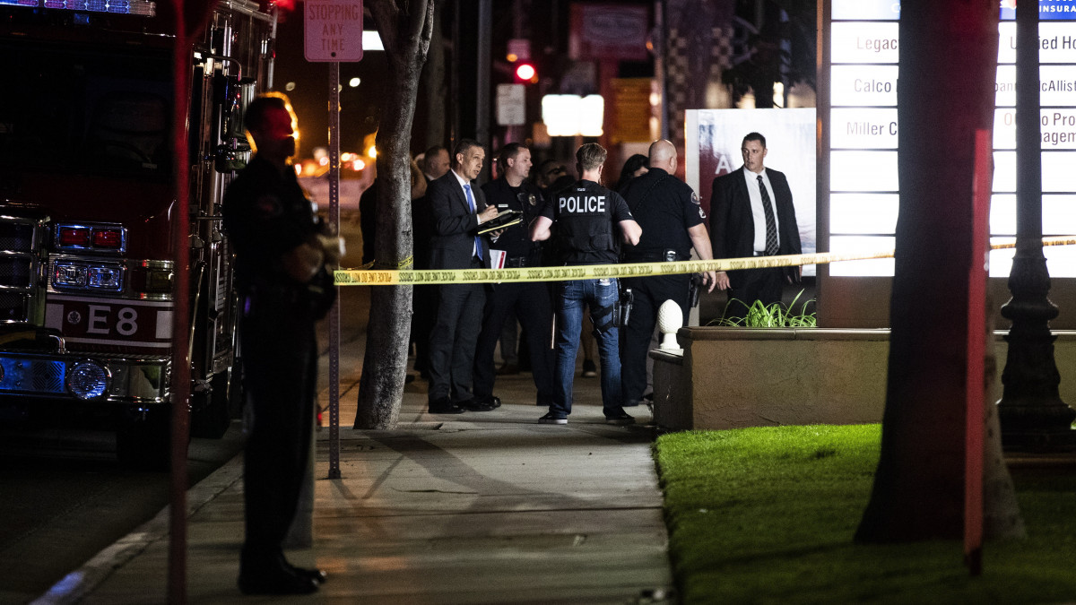 Orange megye rendőrei állnak egy irodaépület előtt egy lövöldözést követően a Kalifornia állambeli Orange-ban 2021. március 31-én. A támadásban négy ember, köztük egy gyerek vesztette életét, s többen megsérültek, köztük a  feltételezett elkövető is.