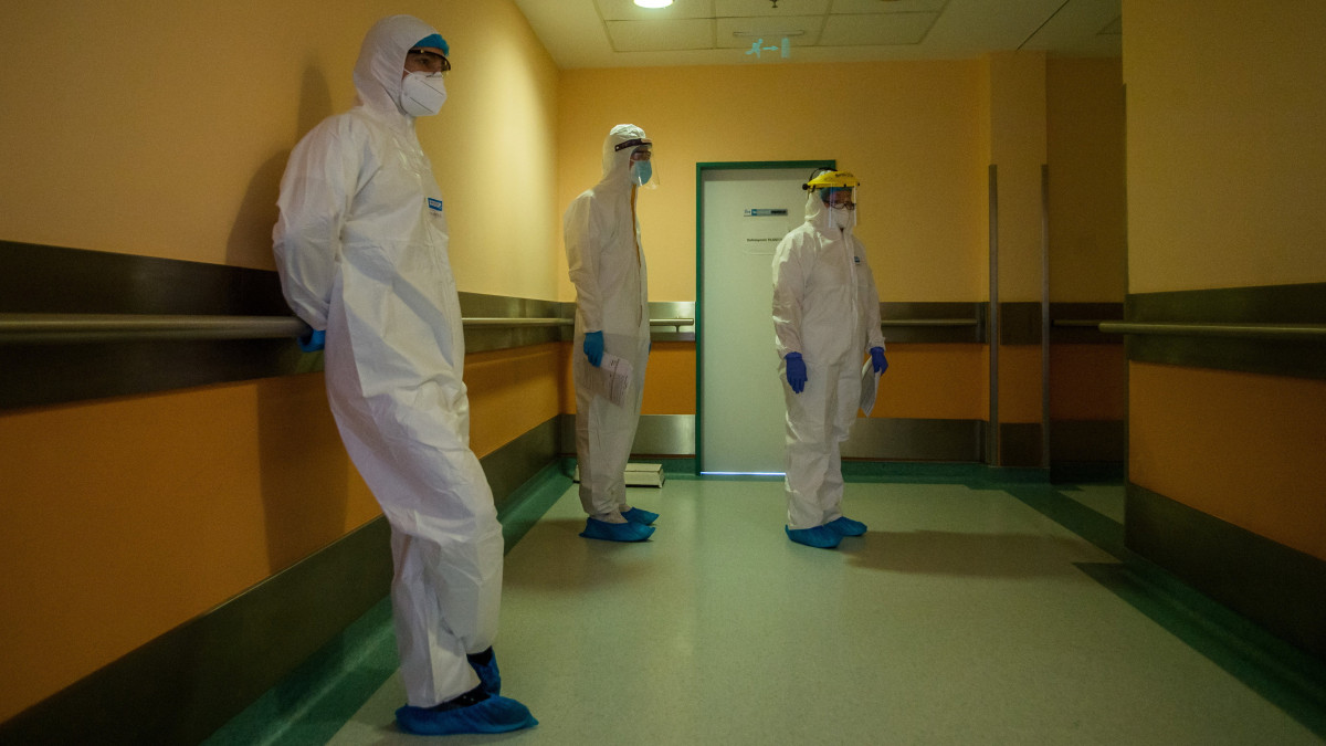 Védőfelszerelést viselő orvosok vizitelnek a fővárosi Honvédkórház koronavírussal fertőzött betegek fogadására kialakított osztályán 2021. április 1-jén.