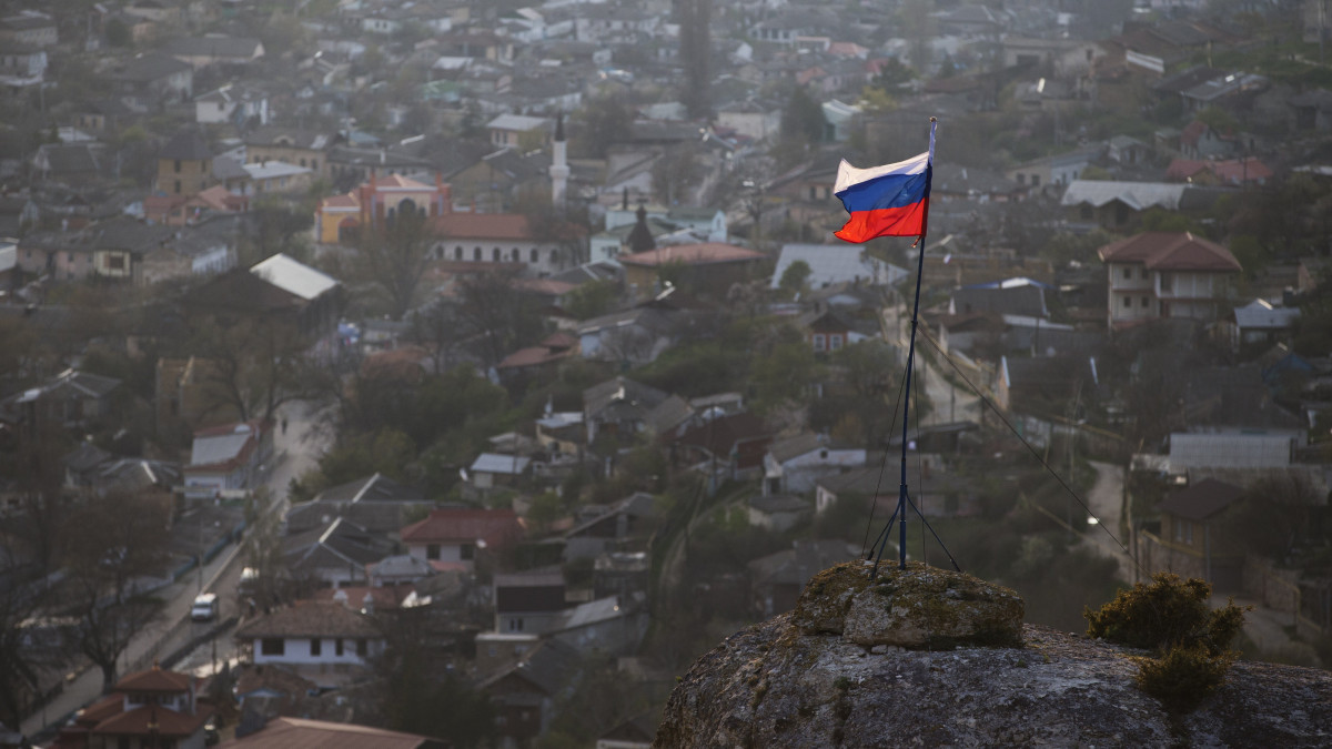 A 2021. március 18-án közreadott képen orosz zászló lobog egy hegy tetején, az Ukrajnához tartozó Krím félszigeten fekvő Bahcsiszaraj közelében 2014. március 28-án. A világ hét legfejlettebb iparú országának (G7) képviselői 2021. március 18-án  közös állásfoglalást adtak ki, amelyben felhívták a moszkvai vezetés figyelmét, hogy nem ismerik el a Krím félsziget Oroszország általi elcsatolását, valamint továbbra is támogatják Ukrajna függetlenséghez, szuverenitáshoz és területi integritáshoz való jogát.