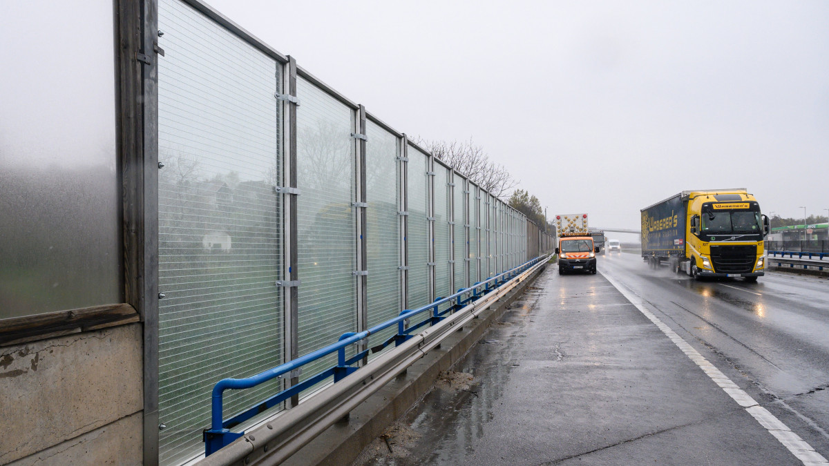 Biztonsági üveg zajvédő fal az M7-es autópályán, Velence közelében 2021. április 13-án. A sztráda velencei szakasza mentén 42 méteren építették ki a magyar fejlesztésben és gyártásban készült átlátszó zajárnyékoló falat. A kísérleti projektben kipróbált biztonsági üveg zajárnyékoló rendszer megfelel a hazai és nemzetközi előírásoknak, sőt, több szempontból túl is teljesíti az akusztikai elvárásokat, ezen felül magasabb biztonságérzetet nyújtanak a közlekedőknek azzal, hogy láthatóvá teszik a hagyományos falak által kitakart épületeket, eseményeket.