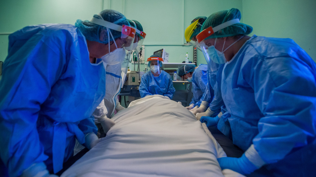 Védőfelszerelést viselő orvosok és ápolók megfordítnak egy beteget a koronavírussal fertőzött betegek fogadására kialakított intenzív osztályon a Szent László Kórházban 2021. április 12-én.