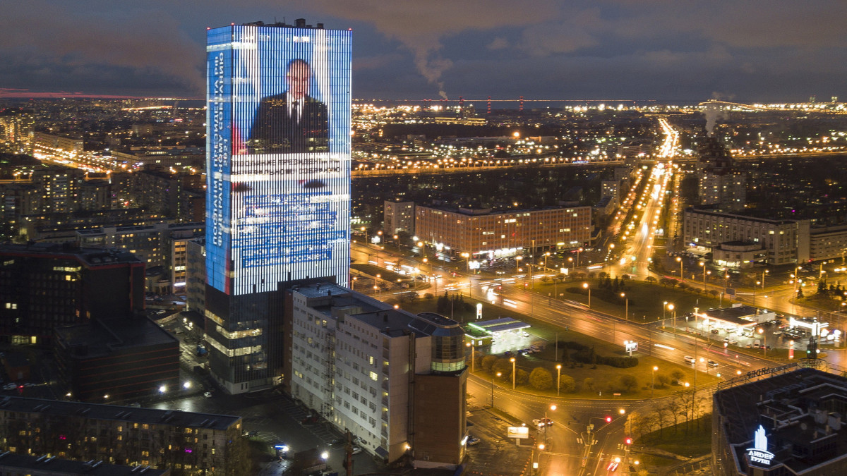 Egy szentpétervári toronyépület óriáskivetítőjén Vlagyimir Putyin orosz elnök látható a parlament két házához intézett éves üzenete közben 2021. április 21-én.