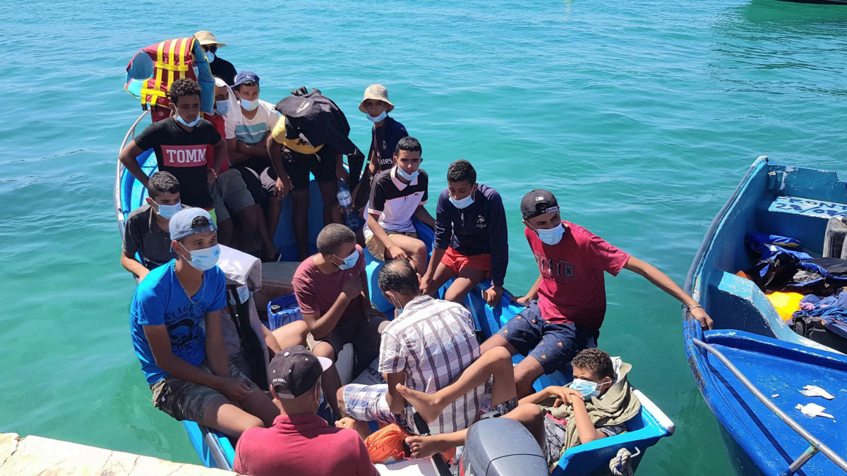 Illegális bevándorlók érkeznek egy csónakban a szicíliai Lampedusa tengerpartjára 2020. augusztus 28-án. Salvatore Martello lampedusai polgármester adatai szerint kevesebb mint két nap alatt negyven csónak kötött ki Lampedusán több mint félezer emberrel.