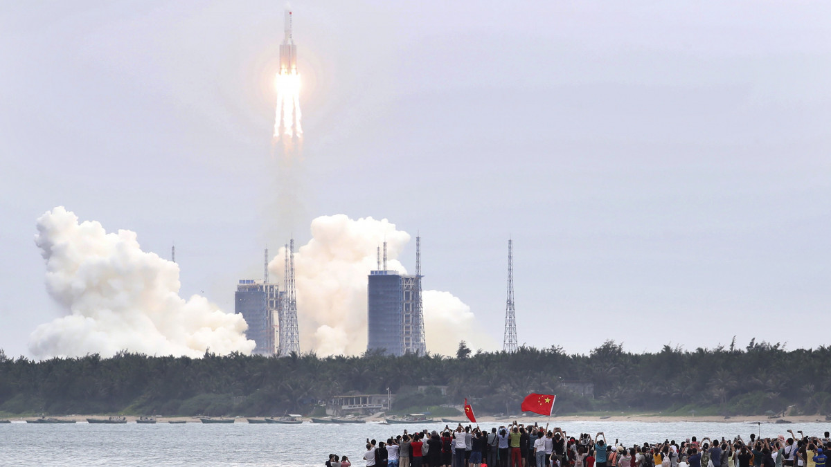  Vencsang, 2021. április 29. A Hszinhua hírügynökség által közreadott képen emberek nézik, amint kilövik a Hosszú Menetelés 5B nevű rakétát a kínai Hainan szigetén található vencsangi űrközpontból 2021. április 29-én. A rakéta viszi fel a világűrbe a leendő állandó űrállomás főmodulját, amelynek neve Tian-he, vagyis Mennyei Harmónia. Ez egy újabb nagy lépés Kína űrkutatási programjában, amelynek keretében az utóbbi hónapokban számos jelentős eredményt értek el.