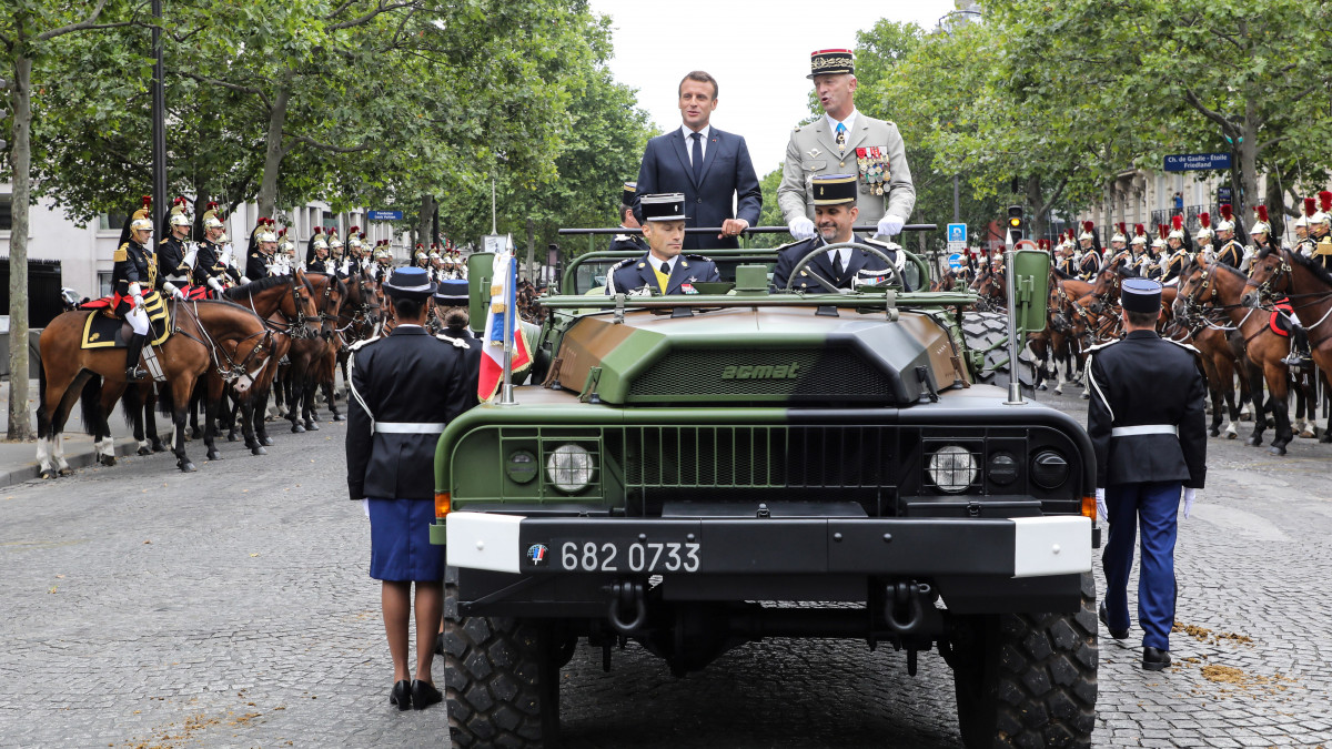 Emmanuel Macron francia elnök (b) és Francois Lecointre tábornok, a francia hadsereg vezérkari főnöke nyitott katonai járműben a párizsi Champs-Élysées sugárúton a Bastille napján rendezett paradén 2019. július 14-én. Franciaország nemzeti ünnepén kulturális eseményekkel, katonai díszszemlével és látványos tűzijátékokkal ünneplik a párizsi várbörtön bevételének 230. évfordulóját.