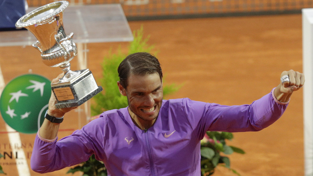 A spanyol Rafael Nadal a trófeával ünnepel, miután tizedszer is megnyerte a római salakpályás tenisztorna férfi versenyét 2021. május 16-án.