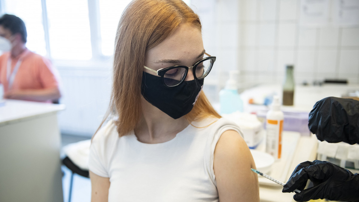 Beoltanak egy fiatalt a német-amerikai fejlesztésű Pfizer-BioNTech koronavírus elleni oltóanyag, a Comirnaty-vakcina első adagjával a Jósa András Oktatókórházban kialakított oltóponton Nyíregyházán 2021. május 17-én.