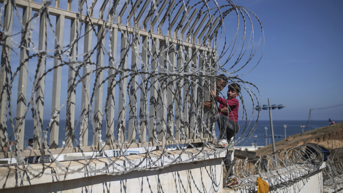 Marokkói  illegális bevándorlók másznak át a Marokkó területébe ékelődő észak-afrikai spanyol enklávé, Ceuta határkerítésén 2021. május 18-án. Egy nap alatt több mint hatezren jutottak be illegálisan Marokkóból Ceuta területére. Pedro Sánchez spanyol miniszterelnök bejelentette, hogy minden szükséges eszközzel megvédi Spanyolország területi integritását, határait, amelyek egyúttal az Európai Unió külső határai is.