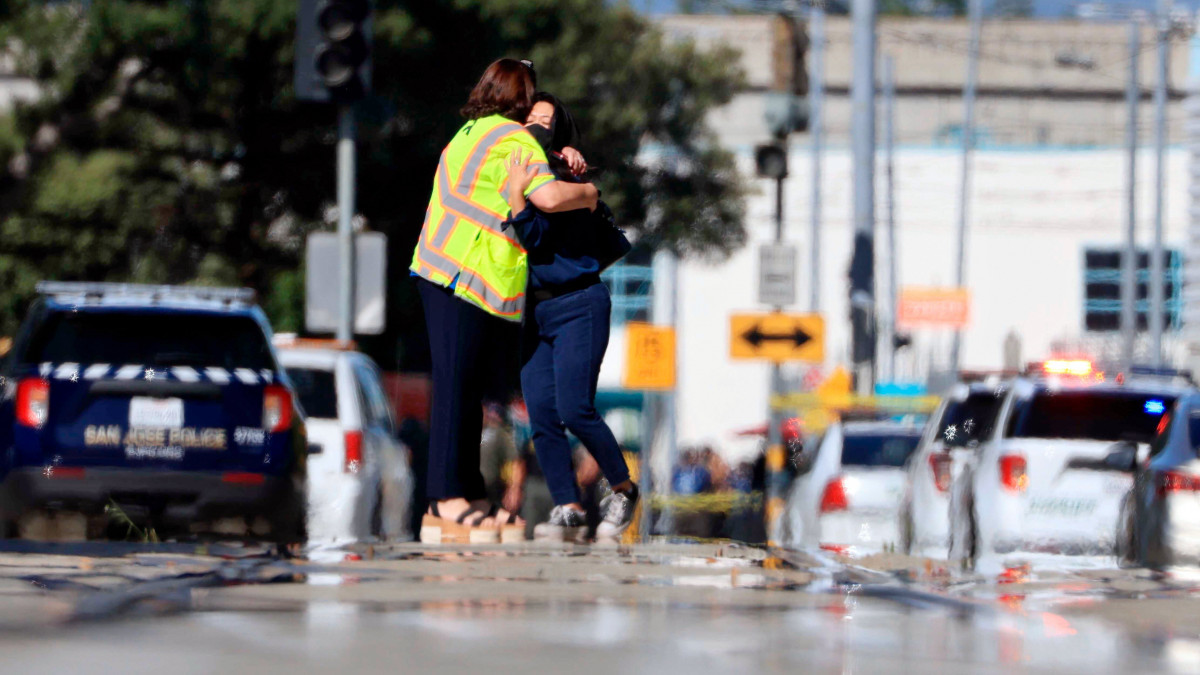Két nő a helyszín mellett 2021. május 26-án, miután egy férfi lövöldözött a kaliforniai San Joséban, a városi vonatok kocsiszínjében. Kilenc ember, köztük a támadó életét vesztette.
