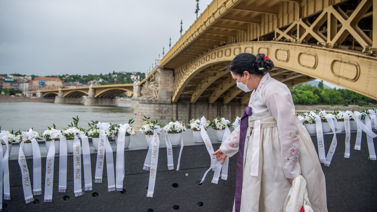 Koreai népviseletbe öltözött megemlékező a Hableány-emlékmű felavatásán Budapesten a Margit híd pesti hídfőjénél 2021. május 31-én. A Hableány sétahajó tragédiájának második évfordulóján avatták fel a baleset áldozatainak emlékművét a szerencsétlenség helyszínén. A Hableány sétahajó 2019. május 29-én süllyedt el Budapesten, a Margit híd közelében, miután összeütközött a Viking Sigyn szállodahajóval. A Hableányon 35-en utaztak, 33 dél-koreai turista és a kéttagú magyar személyzet. Hét turistát sikerült kimenteni, 27 áldozat holttestét megtalálták, egy dél-koreai utast továbbra is eltűntként tartanak nyilván.