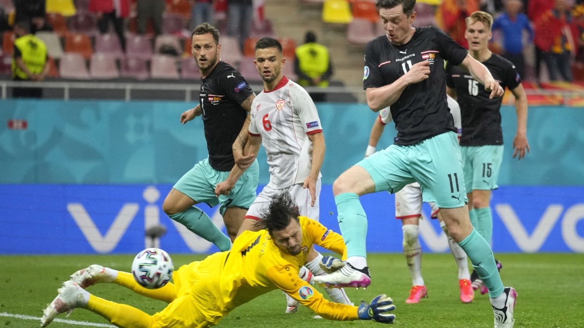Az osztrák Michael Gregoritsch (j) gólt szerez Észak-Macedónia ellen a világméretű koronavírus-járvány miatt 2021-re halasztott 2020-as labdarúgó Európa-bajnokság C csoportjának első fordulójában játszott Ausztria - Észak-Macedónia mérkőzésen a bukaresti Nemzeti Arénában 2021. június 13-án.