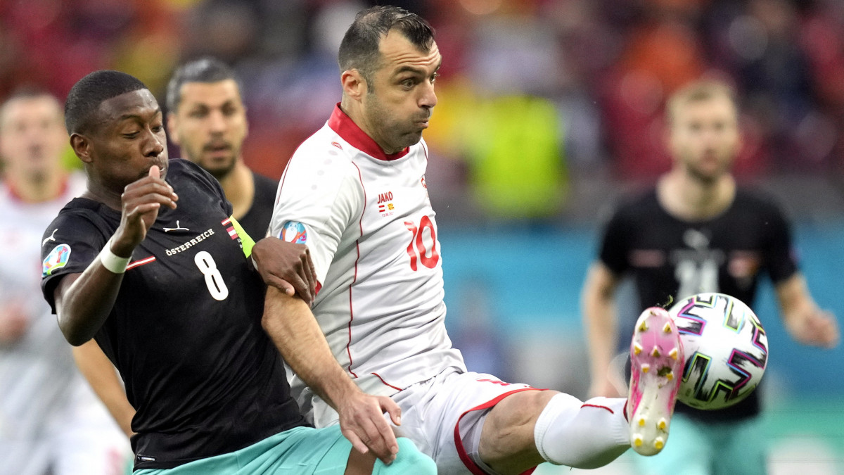 Az osztrák David Alaba (b) és az észak-macedón Goran Pandev a világméretű koronavírus-járvány miatt 2021-re halasztott 2020-as labdarúgó Európa-bajnokság C csoportjának első fordulójában játszott Ausztria - Észak-Macedónia mérkőzésen a bukaresti Nemzeti Arénában 2021. június 13-án.