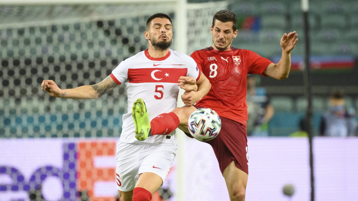 A török Okay Yokuslu (b) és a svájci Remo Freuler a koronavírus-járvány miatt 2021-re halasztott 2020-as labdarúgó Európa-bajnokság A csoportjának harmadik fordulójában játszott Svájc  Törökország mérkőzésen a bakui Olimpia Stadionban 2021. június 20-án.