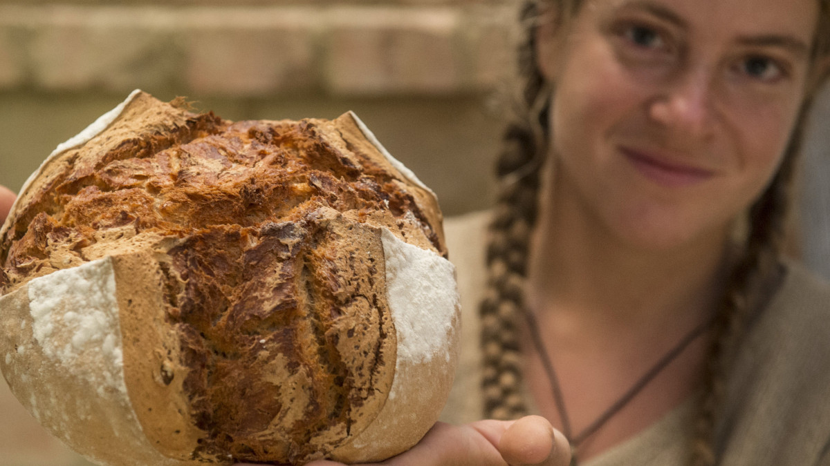 Zaka Dominika frissen sült kenyerét tartja Szentesen álló jurtájában a kenyér világnapján, 2019. október 16-án. A fiatal nő párjával bio lisztekből kovászos kelesztésű kenyereket süt saját maguk és barátaik számára.