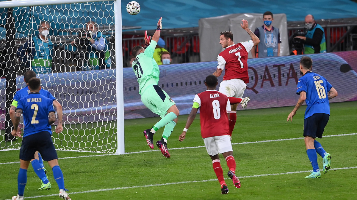 Az osztrák Marko Arnautovic (j2) leshelyzetből érvénytelen gólt fejel a világméretű koronavírus-járvány miatt 2021-re halasztott 2020-as labdarúgó Európa-bajnokság nyolcaddöntőjének Olaszország-Ausztria mérkőzésén a londoni Wembley Stadionban 2021. június 26-án.