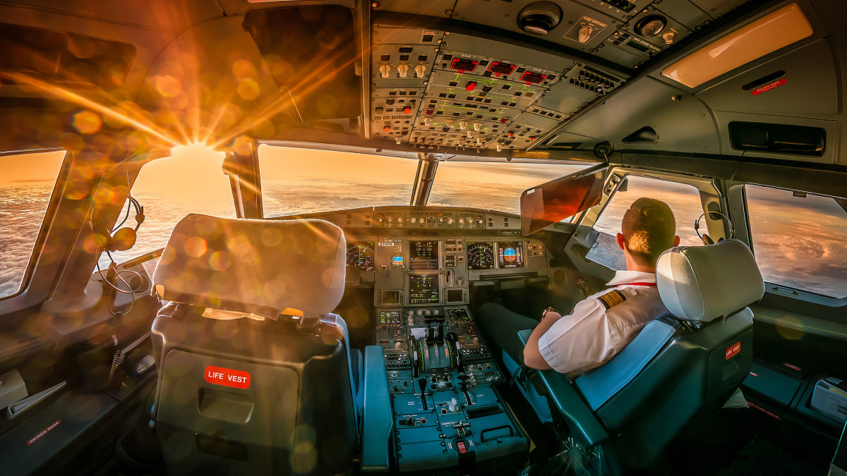 Airline pilot in cockpit watching landscapes, Dubai, United Arab Emirates