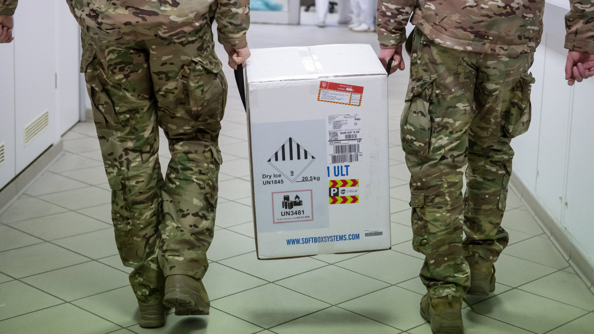 Katonák viszik a koronavírus elleni oltóanyagot, az újonnan érkezett Pfizer-BioNTech-vakcinákat tartalmazó dobozt az egri Markhot Ferenc Kórházban 2021. február 9-én.