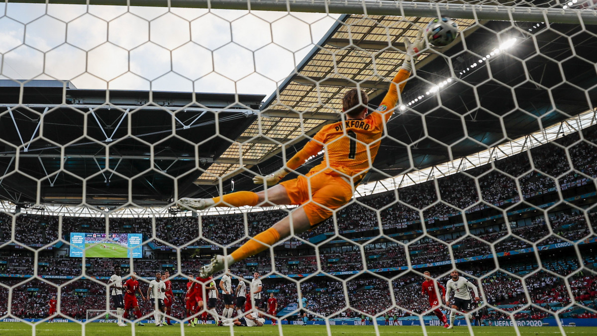 Jordan Pickford angol kapus nem tudja hárítani a dán Mikkel Damsgaard szabadrúgását a koronavírus-járvány miatt 2021-re halasztott 2020-as labdarúgó Európa-bajnokság elődöntőjében játszott Anglia-Dánia mérkőzésen a londoni Wembley stadionban 2021. július 7-én.