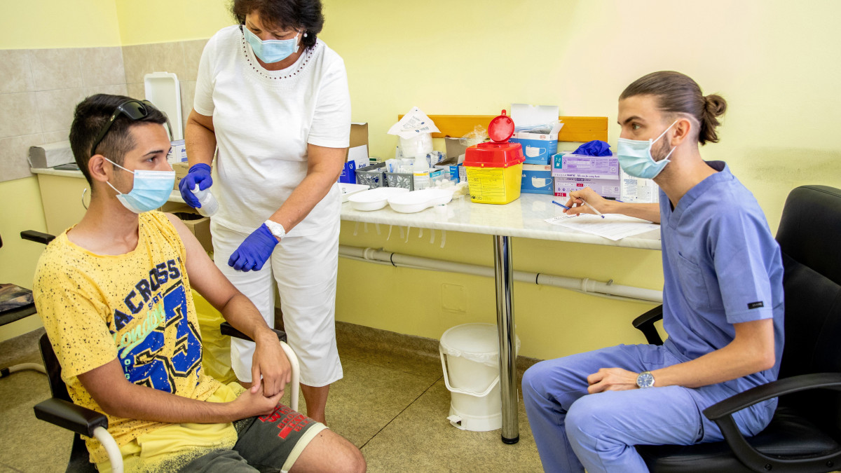 Pallag Andrásné asszisztens fertőtleníti egy férfi karját, mielőtt beoltott a német-amerikai fejlesztésű Pfizer-BioNTech koronavírus elleni oltóanyag, a Comirnaty-vakcina második adagjával a békéscsabai Réthy Pál kórházban 2021. július 13-án. Jobbra Elek Richard Ludovic orvos.