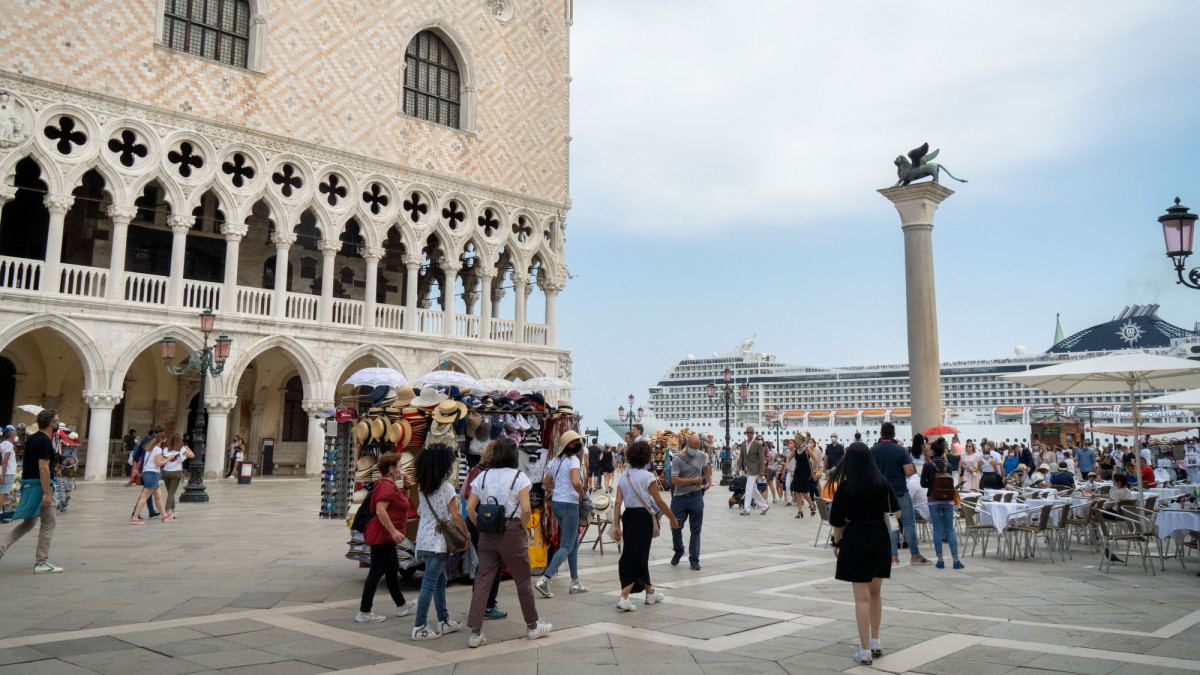 Tourists watch as the MSC Orchestra cruise ship passes Palazzo Ducale as it departs from the port in Venice, Italy, on Saturday June 5, 2021. Italys economy is likely to grow more than 4% in 2021 as the funds kick in and businesses reopen, Bank of Italy Governor Ignazio Visco said last week. Photographer: Giulia Marchi/Bloomberg via Getty Images