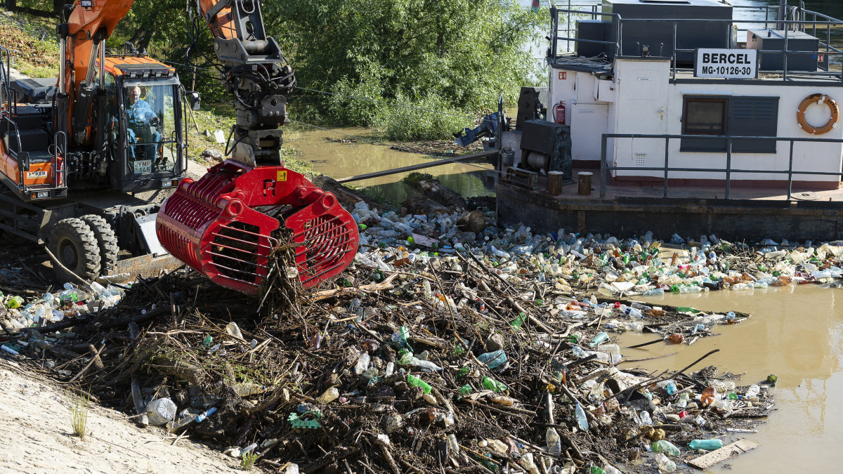A Felső-Tisza-Vidéki Vízügyi Igazgatóság munkatársai munkagépekkel szedik ki a romániai vízgyűjtőről érkező hulladékot a Szamosból Olcsvánál 2021. május 21-én.