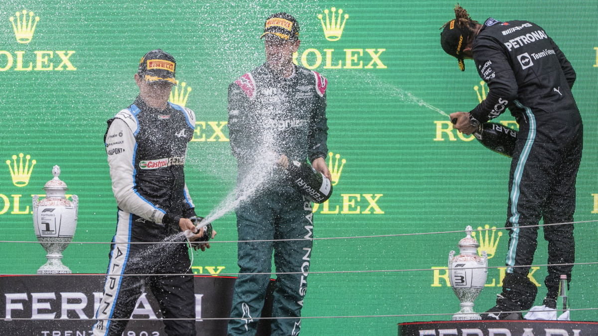 A győztes Esteban Ocon, az Alpine francia versenyzője (b), a második helyezett Sebastian Vettel, az Aston Martin német versenyzője (k) és a harmadik Lewis Hamilton, a Mercedes brit versenyzője (j) a dobogón a Forma-1-es Magyar Nagydíj díjátadóján a mogyoródi Hungaroringen 2021. augusztus 1-jén.