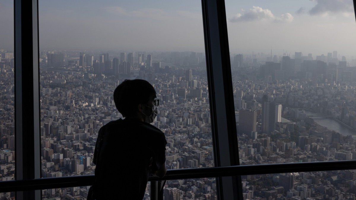 TOKYO, JAPAN - JULY 28: A visitor wearing a face mask views the city skyline from the Tokyo Skytree on July 28, 2021 in Tokyo, Japan. Tokyo metropolitan government reported 3,177 new coronavirus cases on Tuesday, an increase on yesterday and the highest number of infections recorded so far for the city. As the Olympics gets fully underway, concern continues to linger around the safety of holding such a large event during the global Covid-19 pandemic. (Photo by Carl Court/Getty Images)