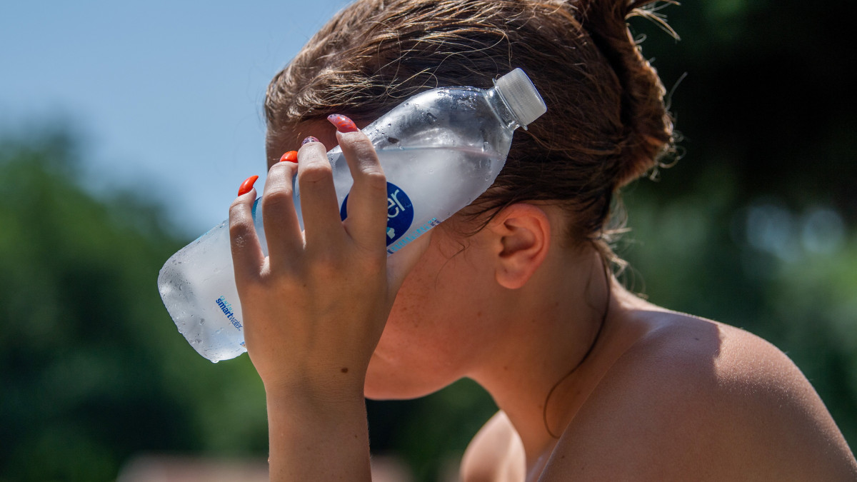 Palackozott, jéghideg vízzel hűsíti magát egy lány a Római strandfürdőben 2021. június 29-én. A tartós hőség veszélye miatt több megyére harmadfokú figyelmeztetést adott ki az Országos Meteorológiai Szolgálat.