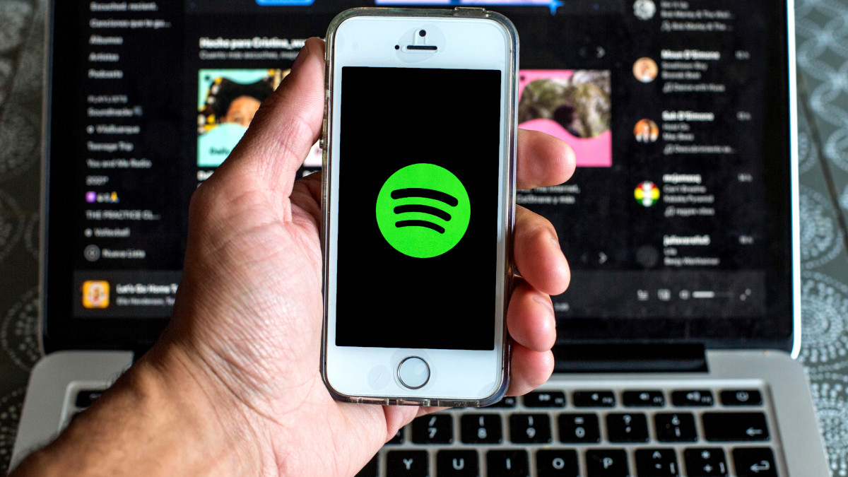 SPAIN - 2021/03/24: In this photo illustration the Spotify Music app seen displayed on a smartphone screen and a Spotify website displayed on laptop in the background. (Photo Illustration by Thiago PrudĂŞncio/SOPA Images/LightRocket via Getty Images)