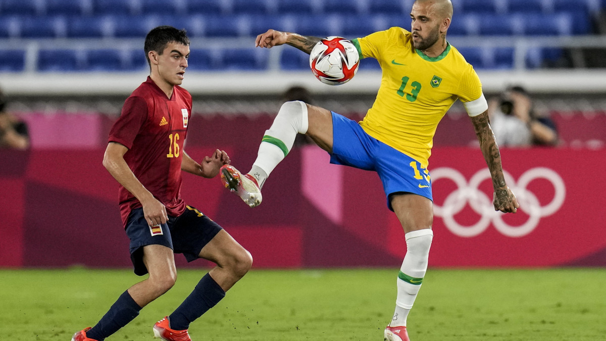 A spanyol Pedri Gonzalez (b) és a brazil Dani Alves a világméretű koronavírus-járvány miatt 2021-re halasztott 2020-as tokiói nyári olimpia férfi labdarúgótornájának döntőjében játszott Brazília-Spanyolország mérkőzésen a Jokohamai Nemzetközi Stadionban 2021. augusztus 7-én.