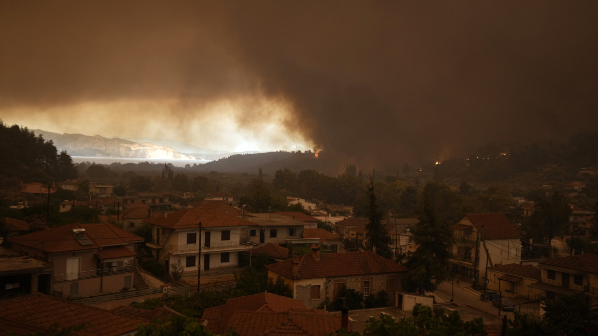 Erdőtűz lángjai közelítenek a görögországi Évia-szigeten fekvő Guvesz falu felé 2021. augusztus 8-án. A görögországi erdőtüzek a leginkább Évia szigetét sújtják.