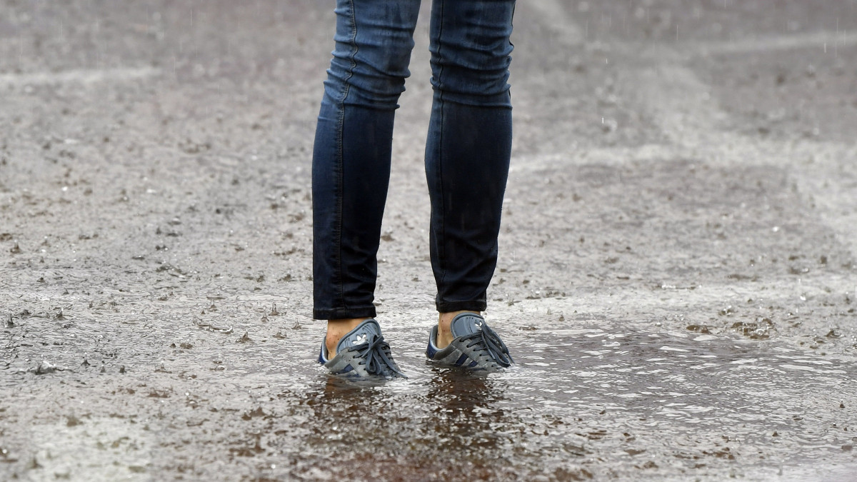 Gyalogos a felhőszakadás miatt felgyülemlett esővízben, az esztergomi Széchenyi téren 2021. augusztus 5-én.