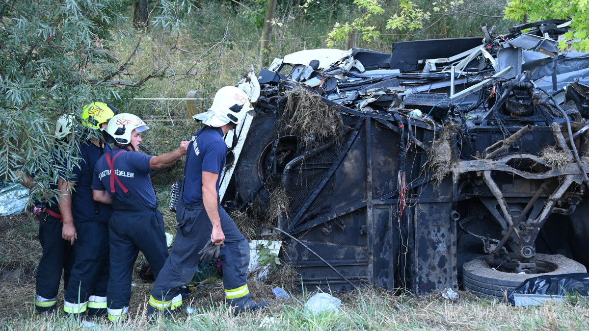 Tűzoltók az M7-es autópálya mellett Szabadbattyán közelében, ahol árokba borult egy autóbusz 2021. augusztus 15-én hajnalban. A balesetben legalább nyolcan meghaltak.