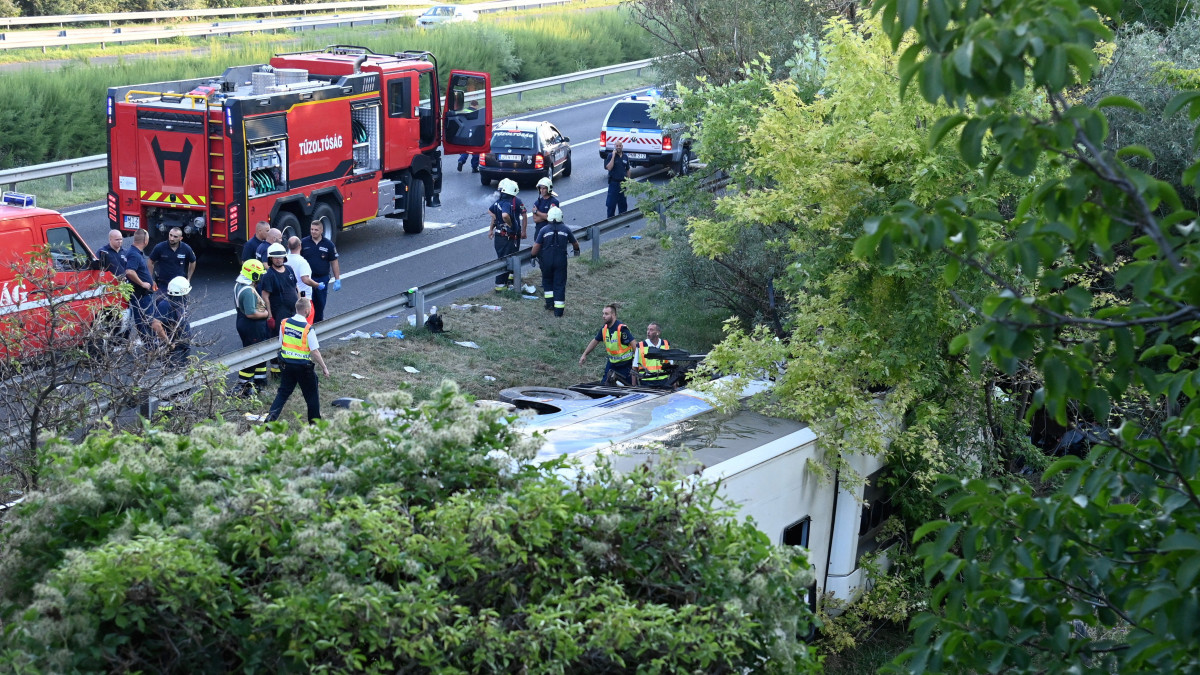 Tűzoltók az M7-es autópálya mellett Szabadbattyán közelében, ahol árokba borult egy autóbusz 2021. augusztus 15-én hajnalban. A balesetben legalább nyolcan meghaltak.