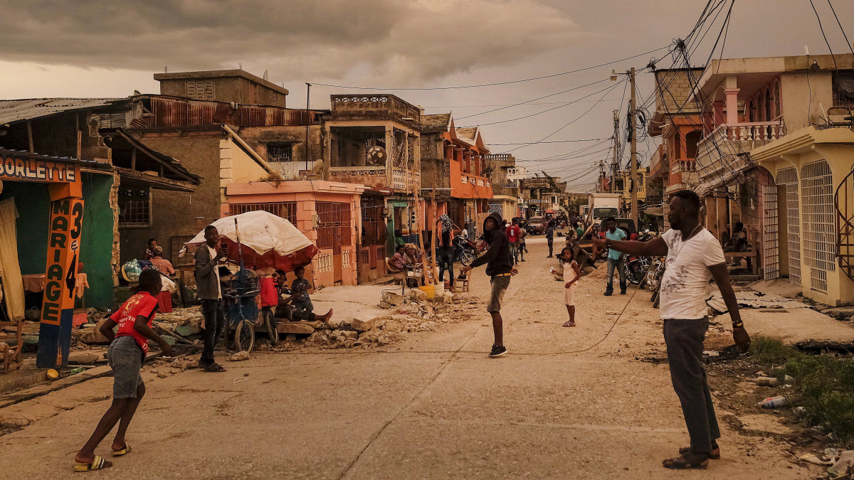 Helyi lakosok az utcán állnak Haiti Les Cayes nevű településén 2021. augusztus 16-án, két nappal a karibi szigetország délnyugati részét megrázó, 7,2-es erősségű földrengés után. Az állami televízió augusztus 17-i tájékoztatása szerint 6900 sérültet és 1419 halálesetet tartanak nyilván.