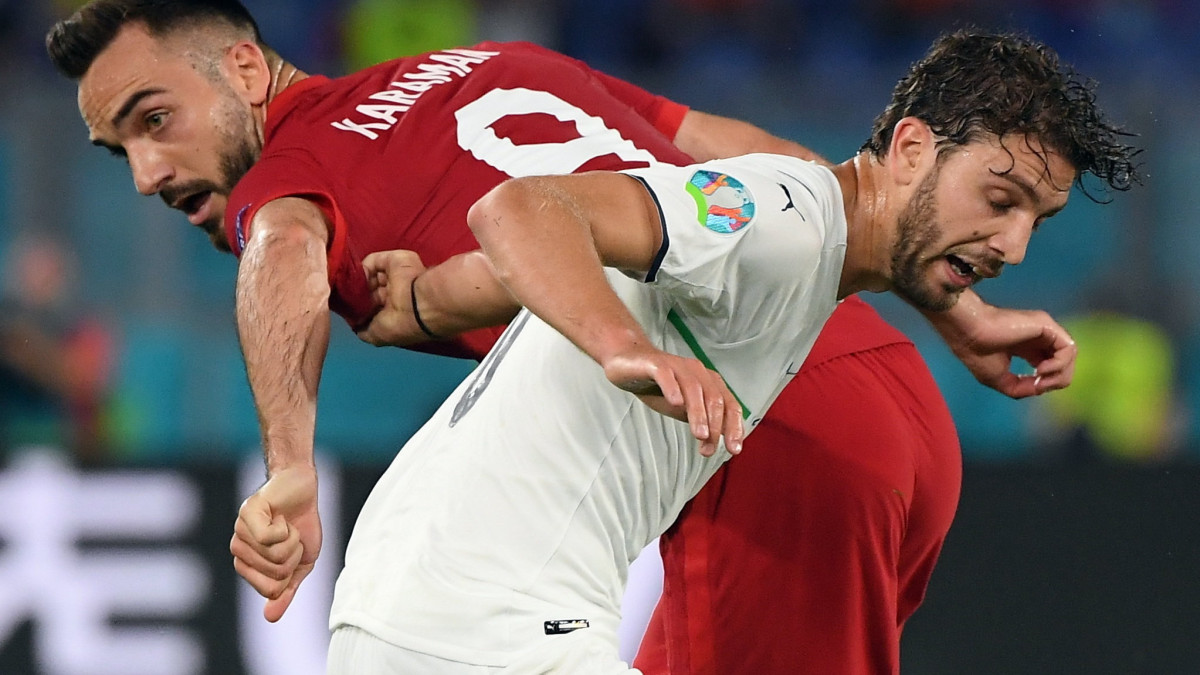 A török Kenan Karaman és az olasz Manuel Locatelli (elöl) a koronavírus-járvány miatt 2021-re halasztott 2020-as labdarúgó Európa-bajnokság A csoportjának első fordulójában játszott Törökország-Olaszország mérkőzésen a római Olimpiai Stadionban 2021. június 11-én.