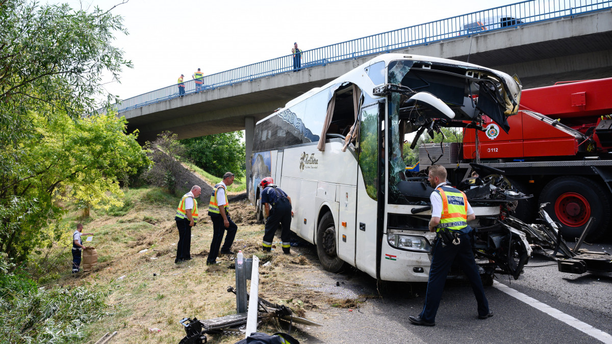 Tűzoltó és rendőrök az árokból kiemelt, hajnalban balesetet szenvedett autóbusznál az M7-es autópálya mellett Szabadbattyán közelében 2021. augusztus 15-én. A balesetben nyolcan meghaltak, nyolcan sérültek meg súlyosan, negyvenen könnyebben. A buszon Horvátországban nyaraló magyar turisták utaztak.