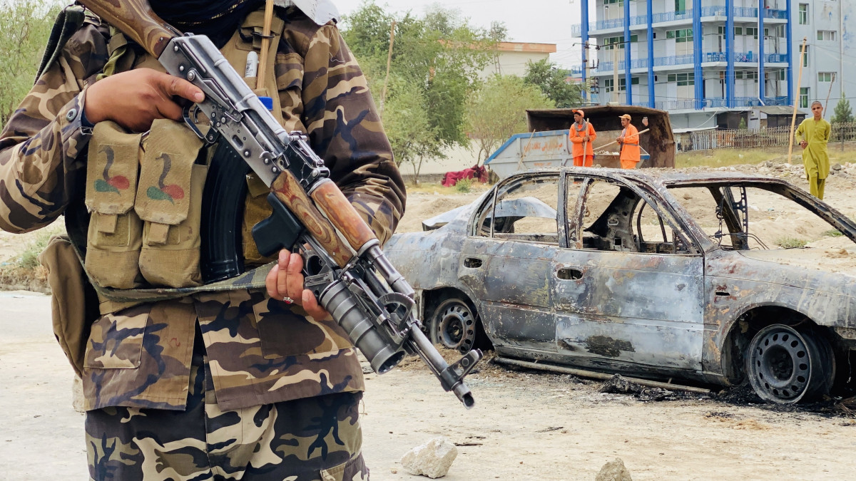 Tálib fegyveres áll egy rakétakilövéshez használt autó roncsa mellett a kabuli Hamid Karzai Nemzetközi Repülőtér közelében 2021. augusztus 30-én. A nap folyamán ismeretlen támadók rakétákat lőttek ki Kabul repülőterére, károkról vagy áldozatokról egyelőre nem tudni.