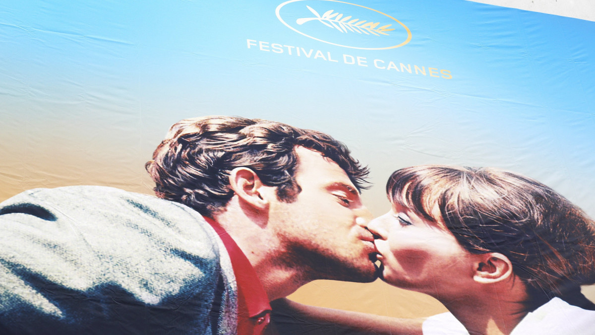 Cannes, 2018. május 6.Kifeszítik a 71. Cannes-i Nemzetközi Filmfesztivál hivatalos plakátját a cannes-i Fesztiválpalota homlokzatára 2018. május 6-án, két nappal az esemény kezdete előtt. A plakáton Jean-Luc Godard francia rendező Bolond Pierrot című 1965-ös filmjének csókjelenete látható Anna Karinával és Jean-Paul Belmondóval. (MTI/EPA/Sebastien Nogier)